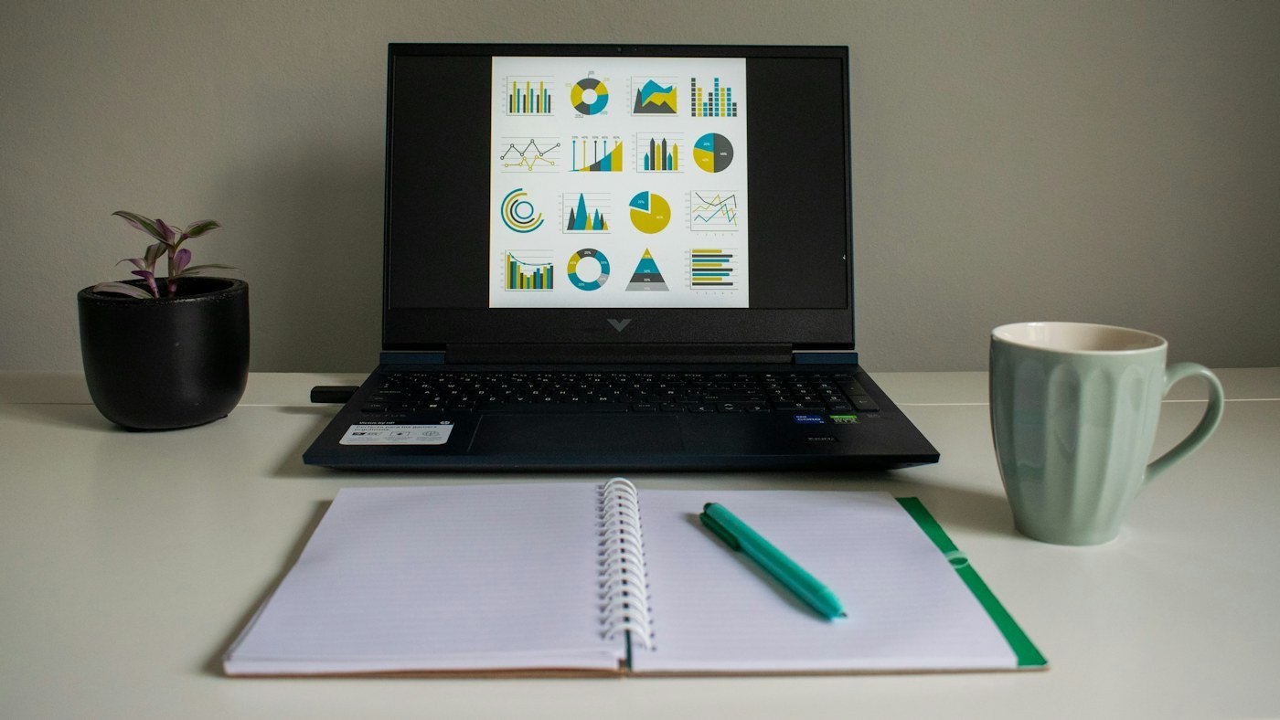 Laptop hiển thị biểu đồ bên cạnh sổ ghi chép